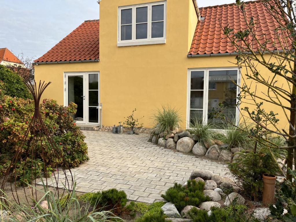 a yellow house with a brick driveway at Lucky 3 Apartments in Løkken
