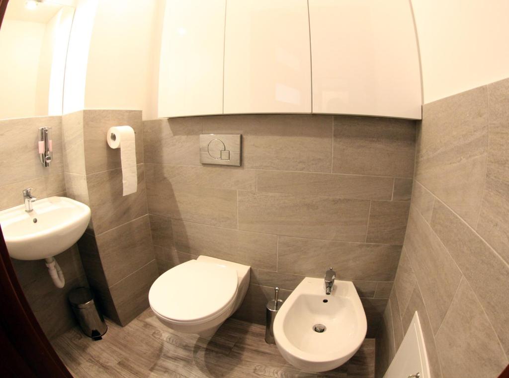 a small bathroom with a toilet and a sink at Apartamenty Pod Telegrafem in Kielce