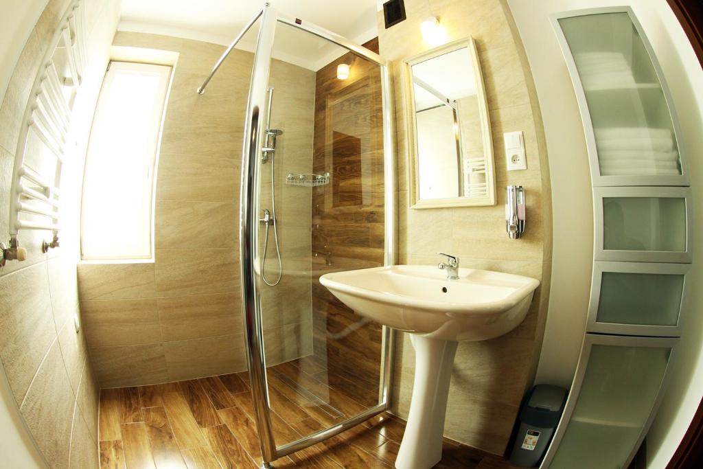 a bathroom with a sink and a shower at Apartamenty Pod Telegrafem in Kielce