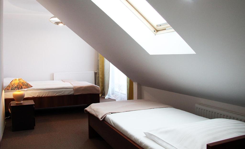 a attic room with two beds and a skylight at Apartamenty Pod Telegrafem in Kielce