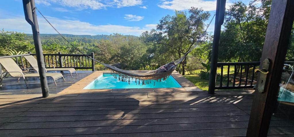 a hammock on a deck next to a pool at Robin Cottage Da Gama Lake in White River