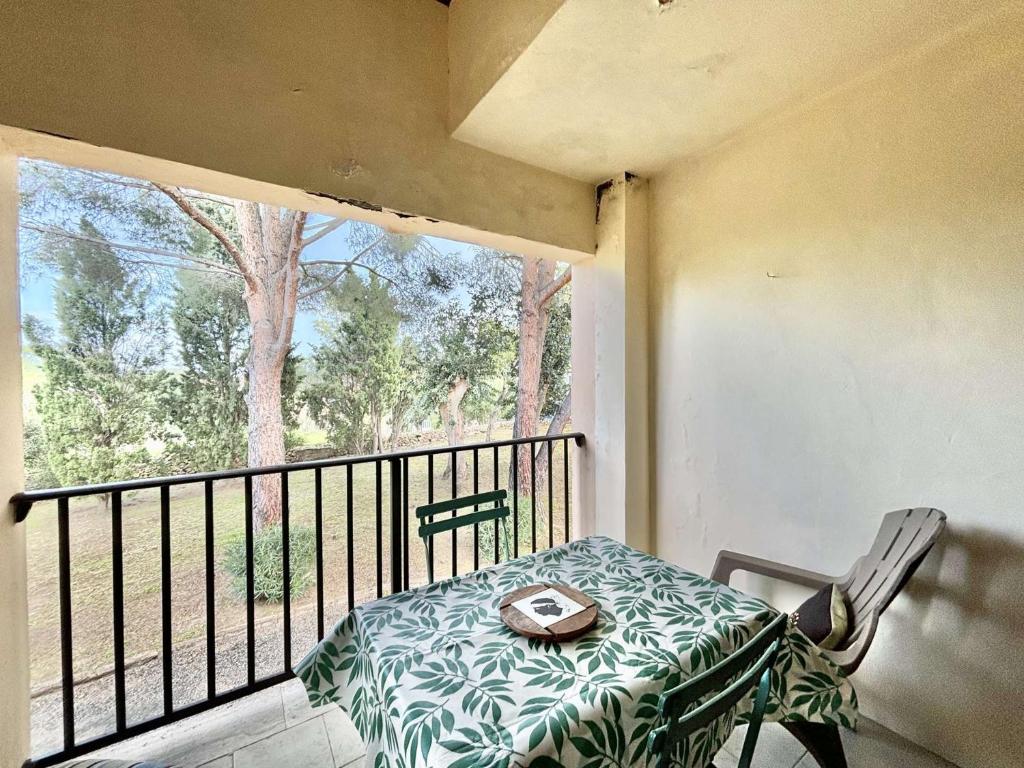 einen Balkon mit einem Tisch und einem Teller darauf in der Unterkunft Studio Résidence de La Mer L'ILE-ROUSSE in LʼÎle-Rousse