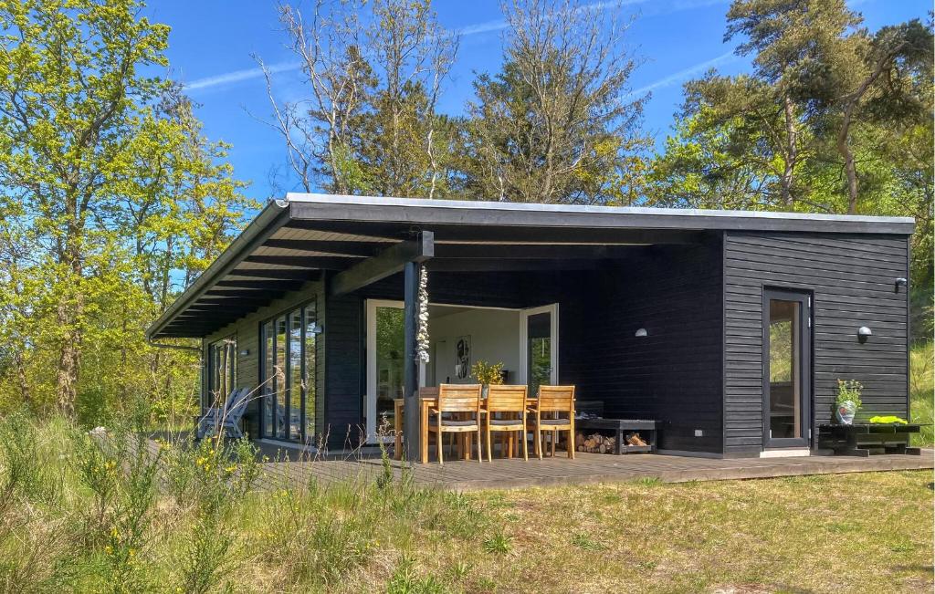 a black tiny house with a table and chairs at Nice Home In Knebel With House Sea View in Knebel