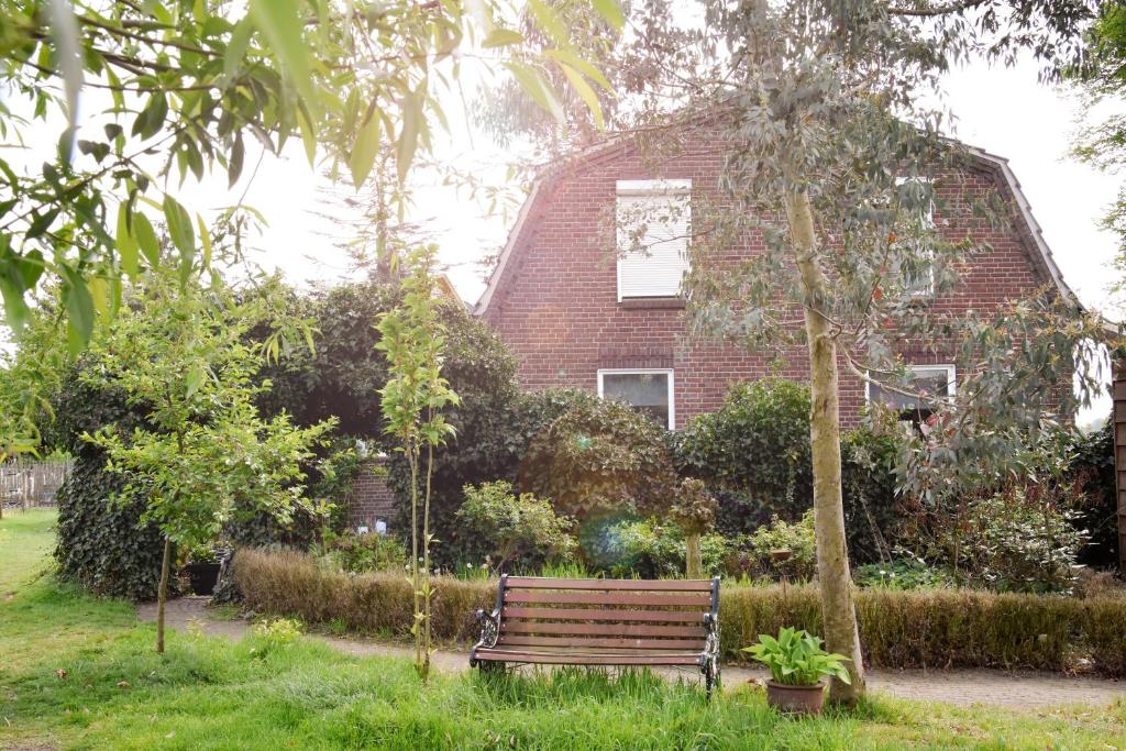 a park bench in front of a brick house at Bed and Breakfast 'Op de Kleijne Hei' in Well