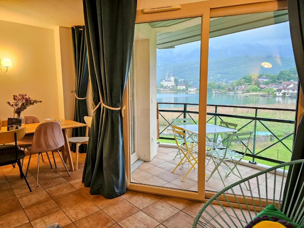 Cette chambre dispose d'un balcon avec vue sur l'eau. dans l'établissement Superbe Duplex les pieds dans l'eau Vue Lac et Château avec Plage et parking Privés, à Duingt