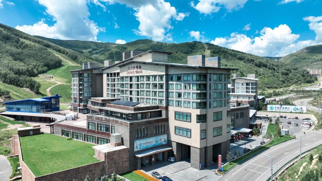 una vista aerea di un hotel con le montagne sullo sfondo di 张家口云顶大酒店 a Chongli