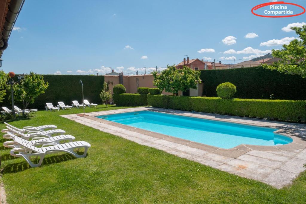 a swimming pool with lounge chairs in a yard at Casas Rurales Florentino in Robledillo