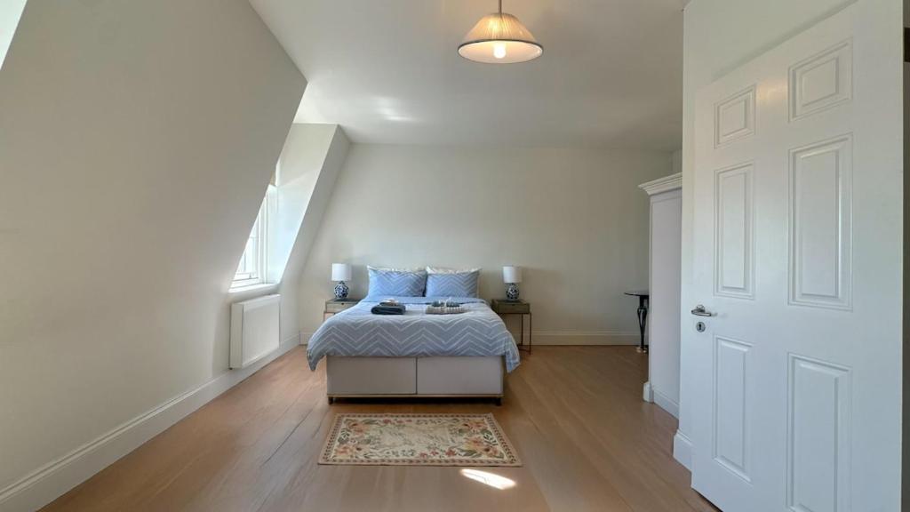 a bedroom with a bed with blue pillows on it at Spacious Guest Studio - En-Suite - Central - Calm View in London