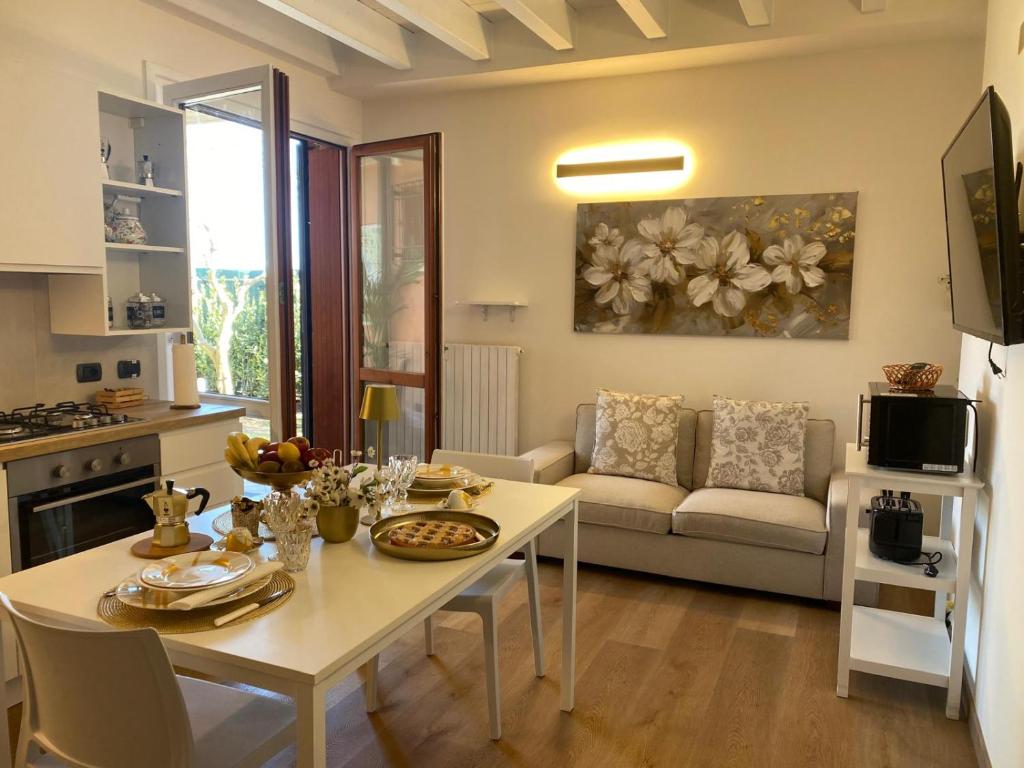 een keuken en woonkamer met een tafel en een bank bij Piccolo Sogno in Desenzano del Garda