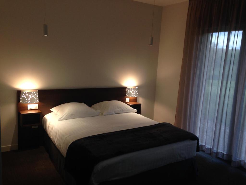 Tempat tidur dalam kamar di Hotel - Restaurant La Claire Forêt