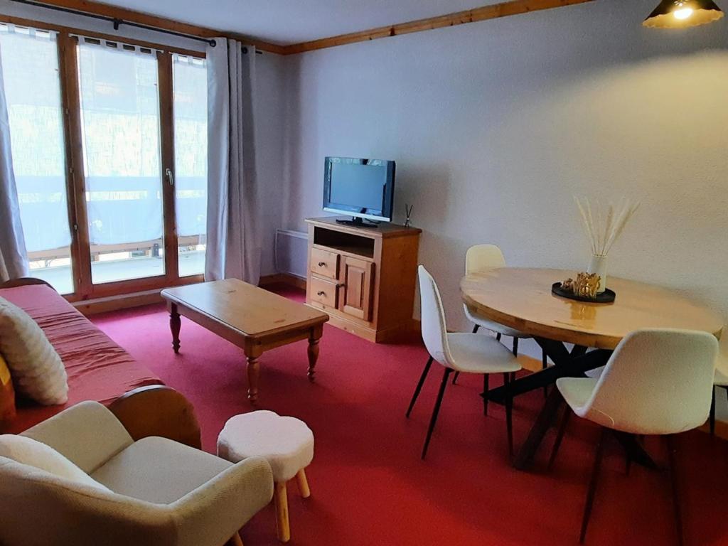 圣母贝莱克Appartement T2 avec balcon et wifi près des pistes - FR-1-807-64的带桌子和电视的客厅