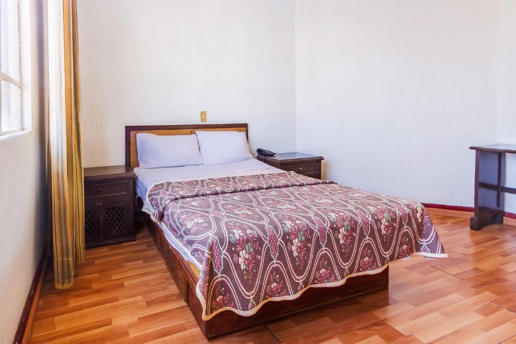 Postel nebo postele na pokoji v ubytování Capital O Nueva Galicia, Guadalajara centro downtown