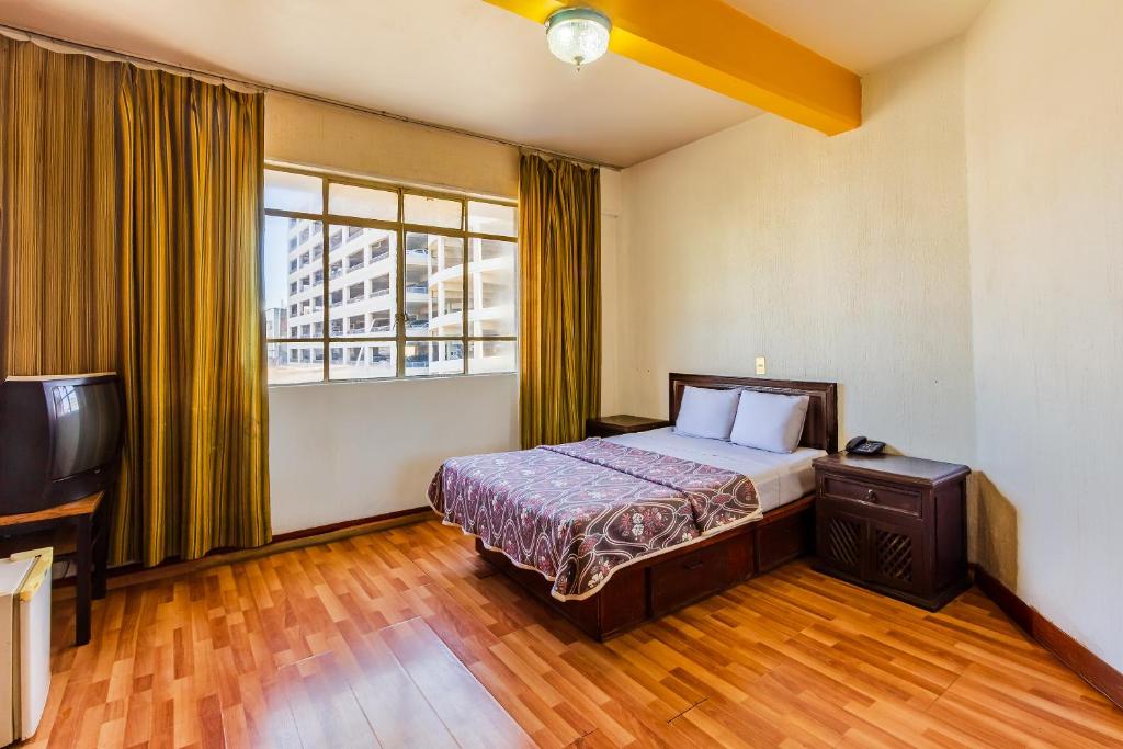 Postel nebo postele na pokoji v ubytování Capital O Nueva Galicia, Guadalajara centro downtown
