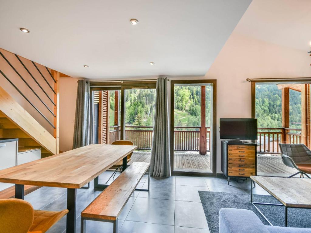 - un salon avec une table en bois et une télévision dans l'établissement Appartement T4 - 6 à 8 pers - Les Gets, parking inclus - FR-1-685-87, aux Gets