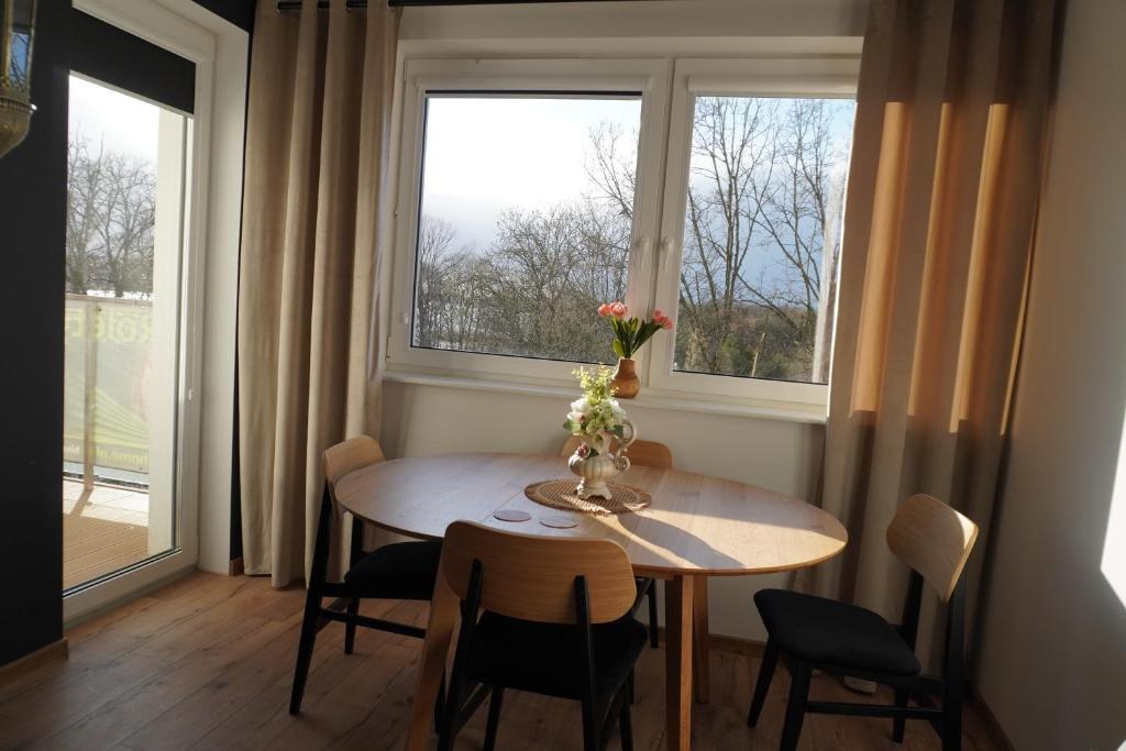 ein Esszimmer mit einem Tisch und einem Fenster in der Unterkunft Apartament 39 City Park Szczecinek in Szczecinek