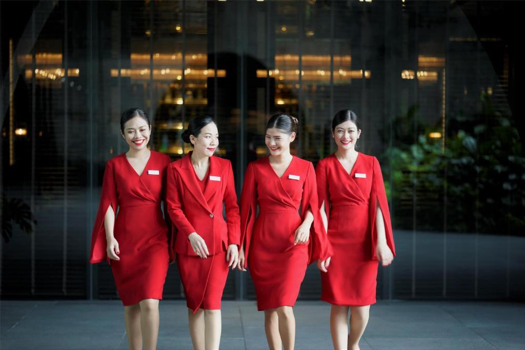 four women in red uniforms standing in front of a building at Sindhorn Kempinski Hotel Bangkok in Bangkok