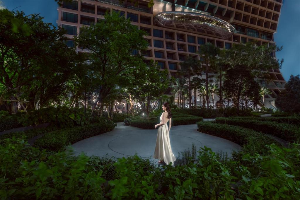 a rendering of a woman in a white dress standing in a garden at Sindhorn Kempinski Hotel Bangkok in Bangkok