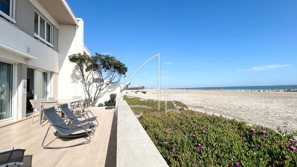 une maison avec des chaises sur une terrasse à côté de la plage dans l'établissement Réf 2152 - T5 en rez-de-plage, à Palavas-les-Flots