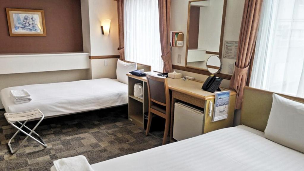 Postel nebo postele na pokoji v ubytování Toyoko Inn Atami Ekimae