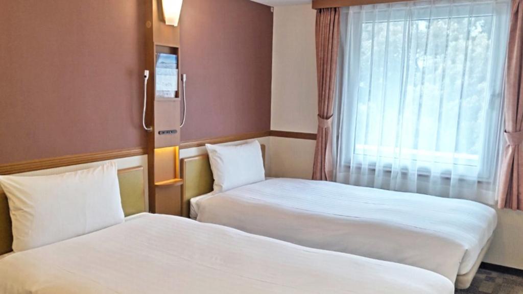 Postel nebo postele na pokoji v ubytování Toyoko Inn Atami Ekimae