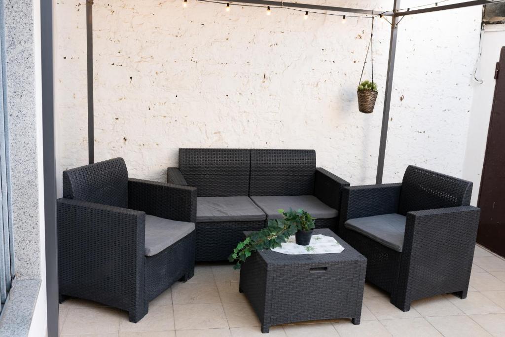 un patio con 2 sedie, un divano e un tavolo di Dimora Emilù a Bari