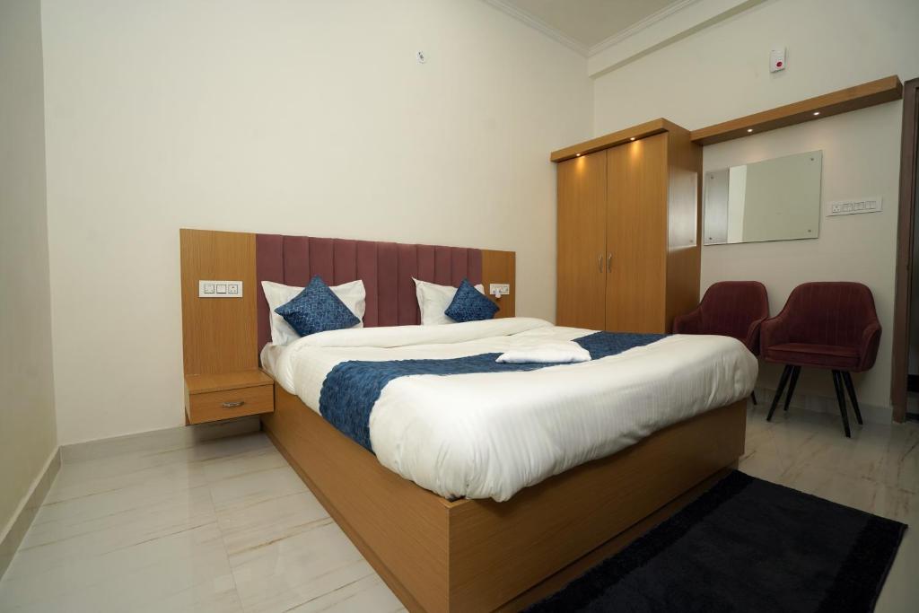 NalmathaHotel Royal Heriage的卧室里有一张大床，配有蓝色枕头