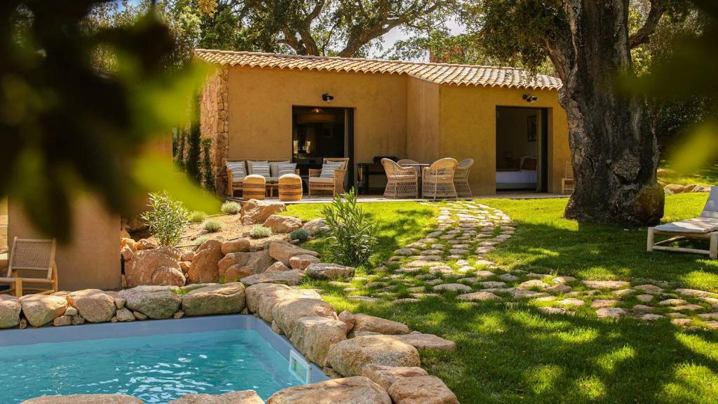 une cour arrière avec une piscine et une maison dans l'établissement Domaine de Gialla Bergerie Quercia, 2 pers, piscine chauffée, 10 mn plage, à Arraggio