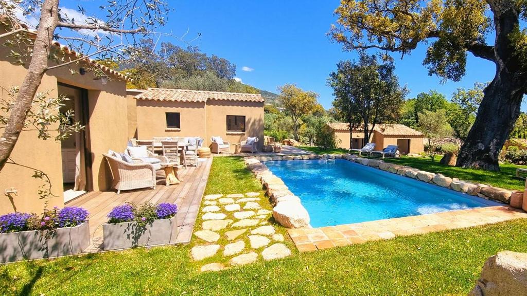 une cour arrière avec une piscine et une maison dans l'établissement Domaine de Gialla Bergerie Prugna, 8 pers, piscine chauffée, 10 mn plage, à Arraggio