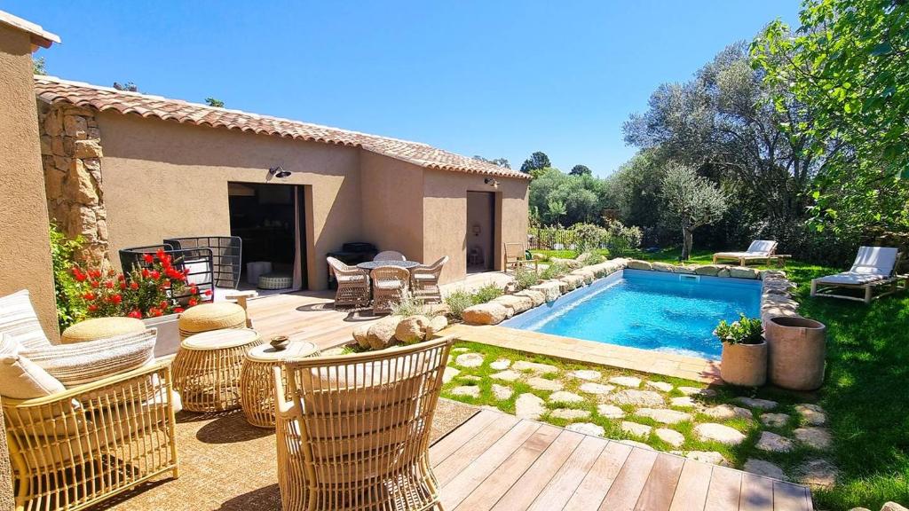 une cour arrière avec une piscine et une maison dans l'établissement Domaine de Gialla Bergerie Figa, 2 pers, piscine chauffée, 10 mn plage, à Arraggio