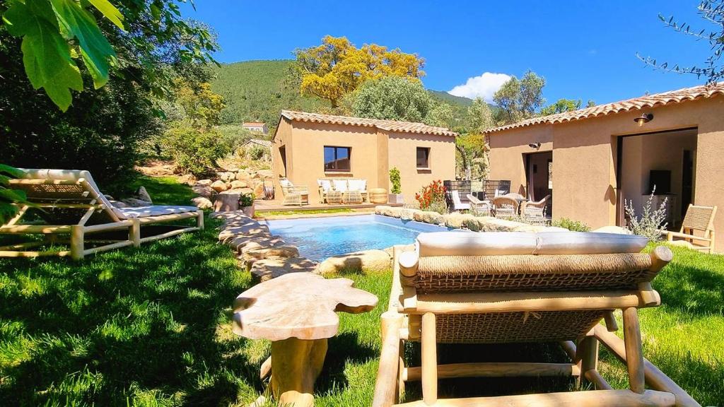 une cour arrière avec une piscine et une maison dans l'établissement Domaine de Gialla Bergerie Figa, 4 pers, piscine chauffée, 10 mn plage, à Arraggio