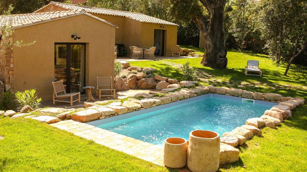 une piscine dans une cour à côté d'une maison dans l'établissement Domaine de Gialla Bergerie Quercia, 4 pers, piscine chauffée, 10 mn plage, à Arraggio