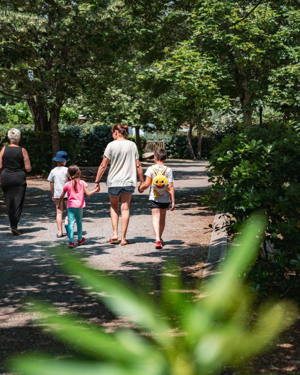 une famille s'adonnant à un chemin dans un parc dans l'établissement Camping Domaine du Cros d'Auzon - Maeva, à Saint-Maurice-dʼArdèche
