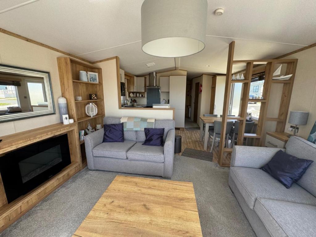 a living room with two couches and a fireplace at Summerleaze 11, Bude in Bude