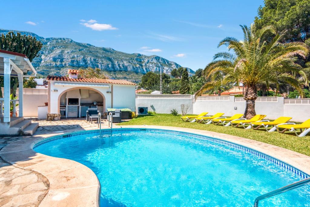 una piscina con sillas y una casa en Villa Sophie, en Denia