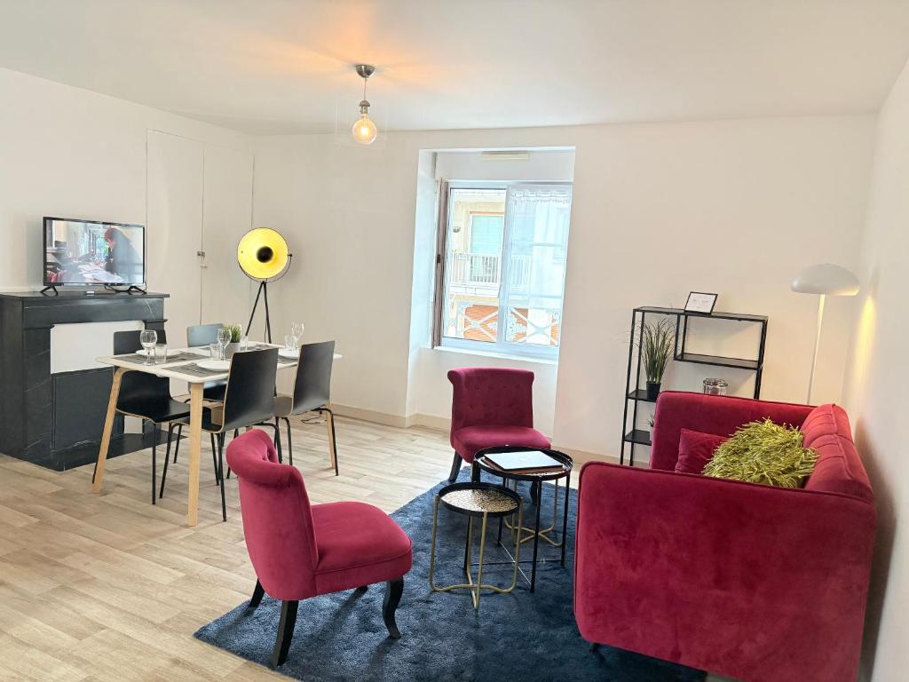 un salon avec des chaises rouges et une table dans l'établissement Hypercentre - 2 chambres - proche commerces, à Cholet