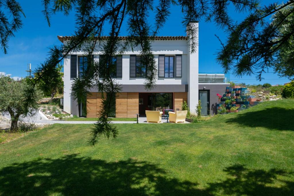 une maison sur une colline avec une cour verte dans l'établissement Sea View Villa In The Hills Of Nice, à Nice