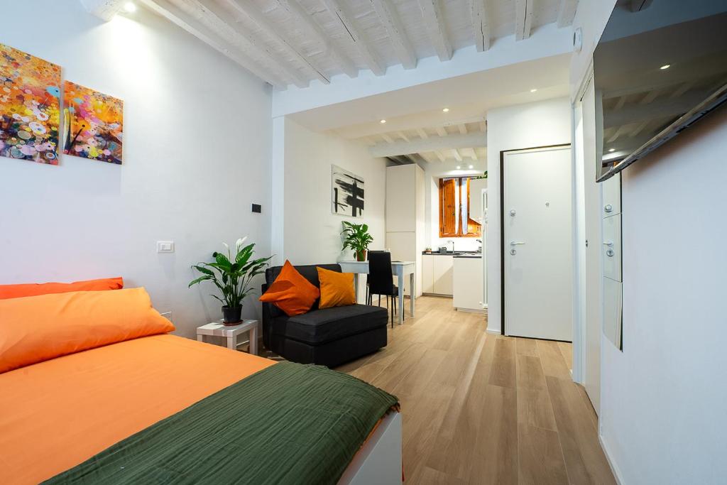 a bedroom with an orange bed and a living room at La Nicchia Apartment- Centralissimo in Siena