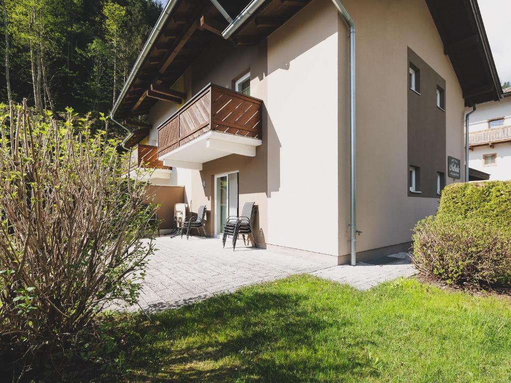 a patio with chairs and a balcony on a building at Chalet Nathalie by we rent in Zell am See