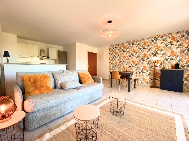 un salon avec un canapé et une table dans l'établissement La Palmeraie T2, terrasse, clim, pkg, centre ville, à Montpellier