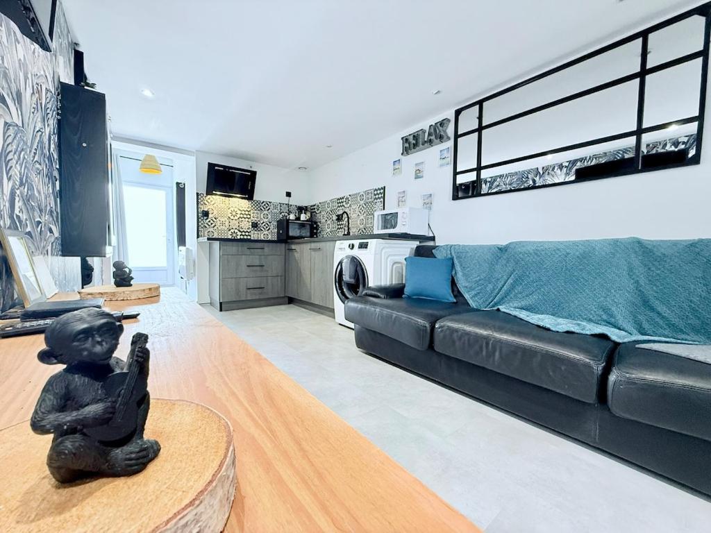 un salon avec un canapé en cuir noir et un salon avec une buanderie dans l'établissement 1753-3 L'atelier secret, à Échillais