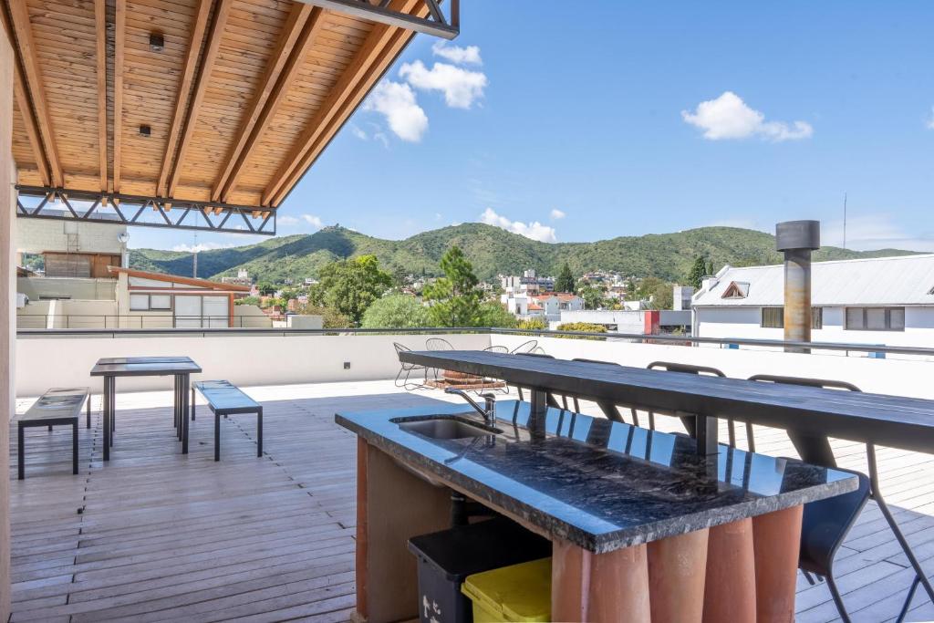 eine Terrasse mit einem Tisch und Stühlen auf dem Dach in der Unterkunft Depto "Ideal" Céntrico, Pile Int y Pile en Terraza, Cochera, Aire Ac in Villa Carlos Paz