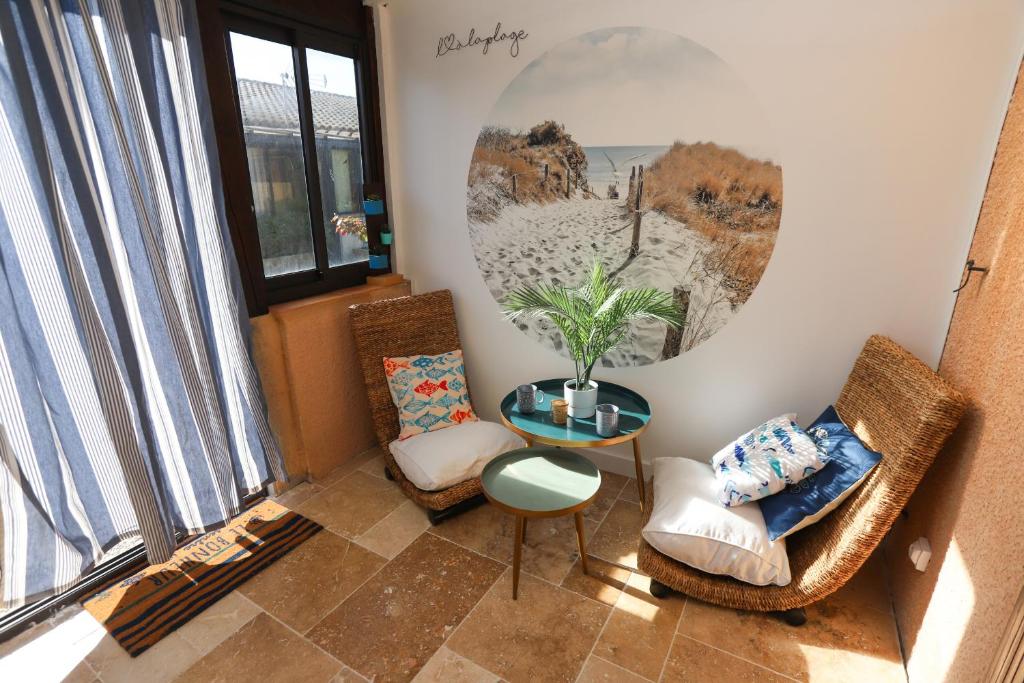 un salon avec deux chaises et une table dans l'établissement St Cyprien Plage jolie maison proche plage, à Saint Cyprien Plage