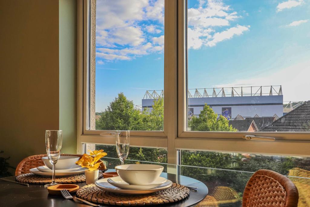 Una mesa de comedor con vista a un puente desde una ventana. en Noah Suite - Central 2BR Apartment with Parking & WIFI, en Cardiff