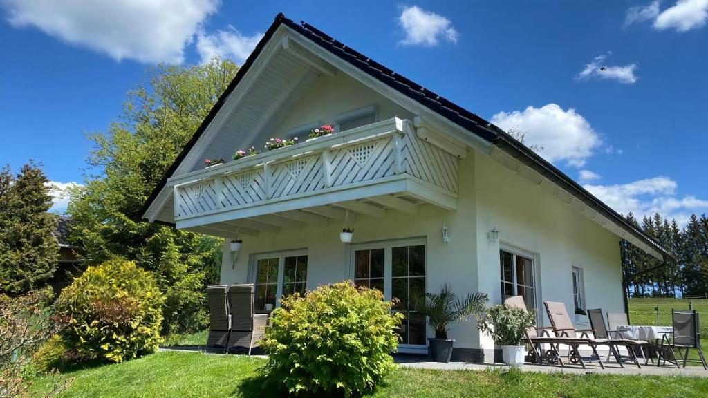 a white house with a balcony on top of it at Ferienhaus Vogtlandresidenz in Beerheide