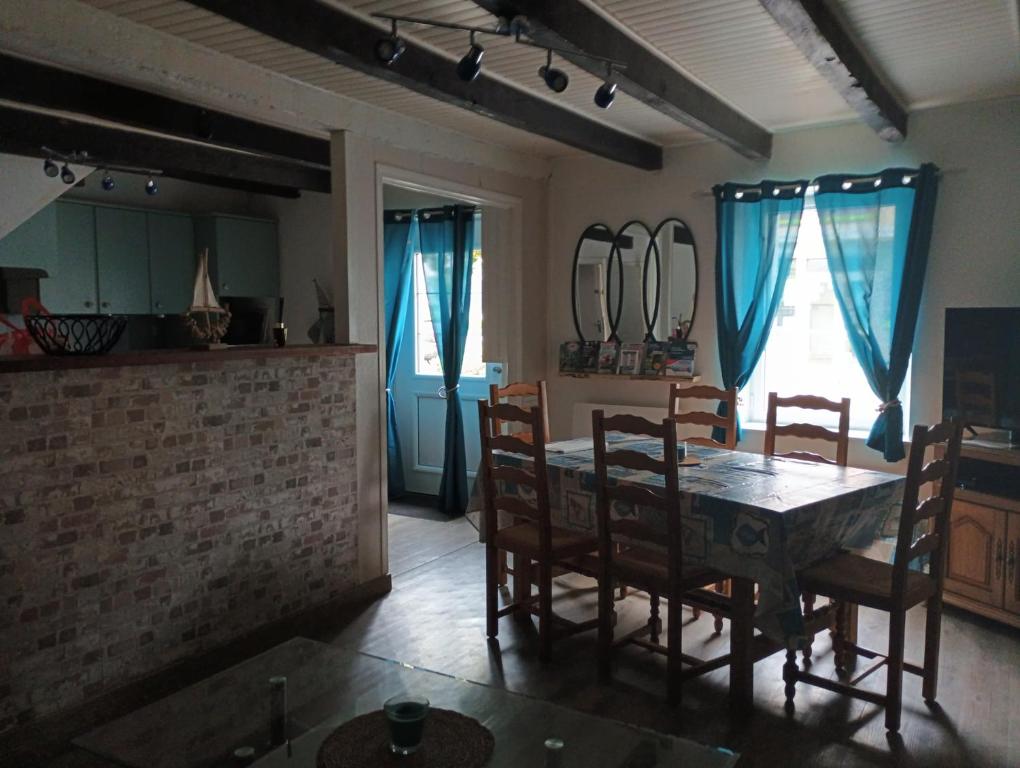 een eetkamer met een tafel en stoelen in een kamer bij Maison de vacances in Languidic