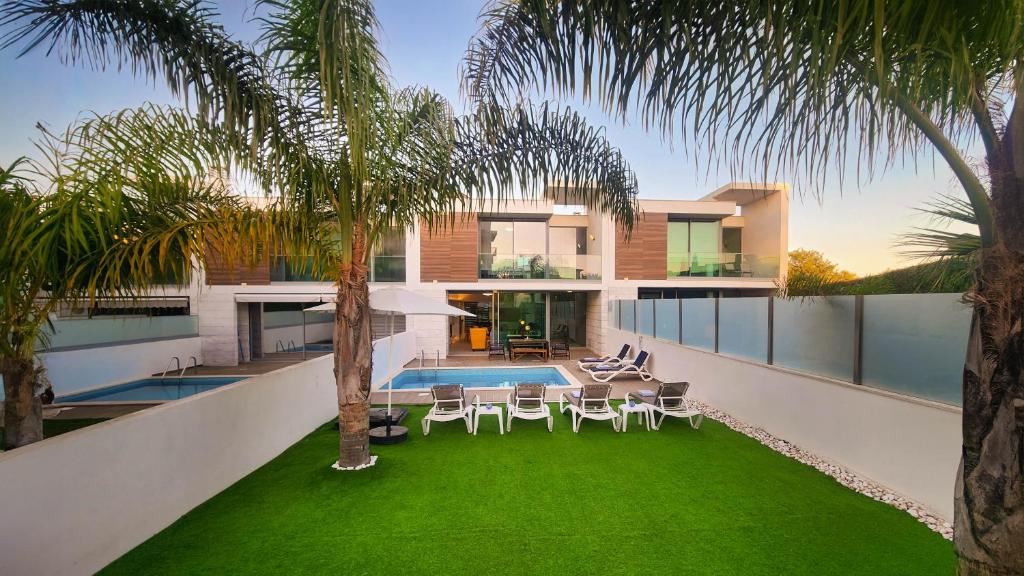 una casa con un patio con sillas y una piscina en Moon by Check-in Portugal, en Albufeira