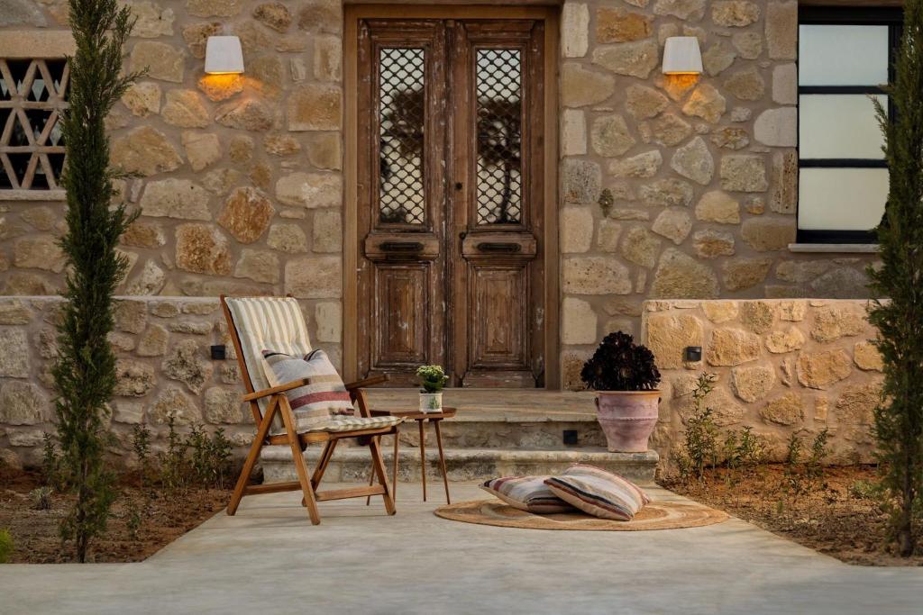 a stone house with a chair and a wooden door at Le tresor de Marie - Charming Traditional Retreat, by ZanteWize in Gaïtánion