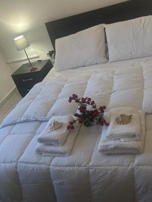 a white bed with towels and flowers on it at STYILEL apartment MIlos 2 in Triovasálos
