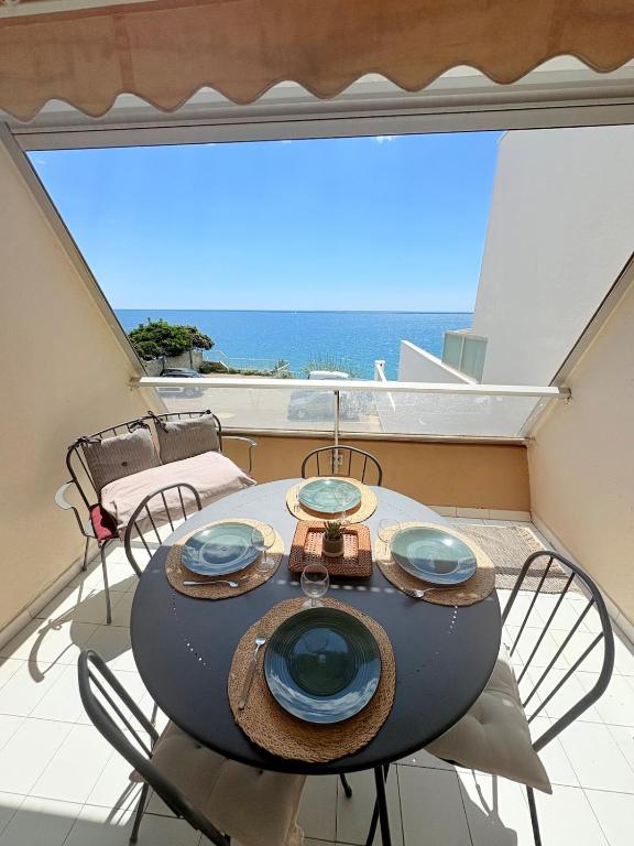 - une table sur un balcon avec vue sur l'océan dans l'établissement Les Sables Fins, Joli Appartement Front de Mer, 1 min des plages, Parking, à Sète