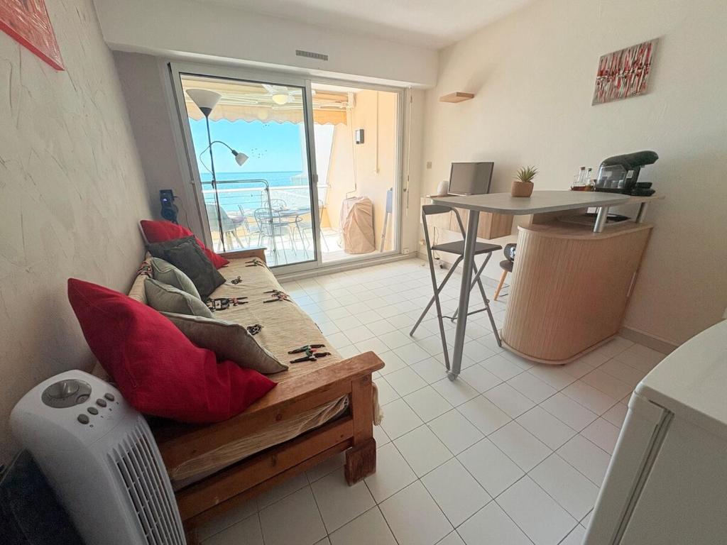 a living room with a couch and a table with a view at Les Sables Fins, Joli Appartement Front de Mer, 1 min des plages, Parking in Sète